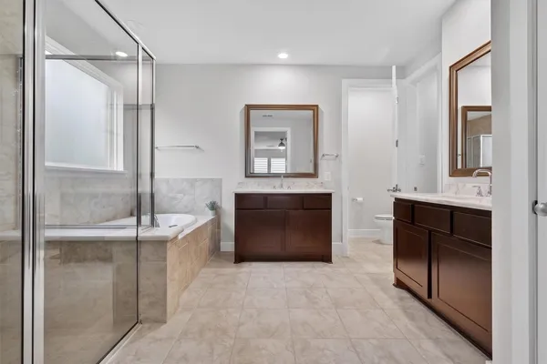 a spacious bathroom with a granite countertop sink a toilet and bathtub