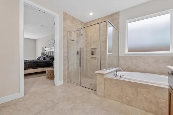 a bathroom with a tub sink and mirror