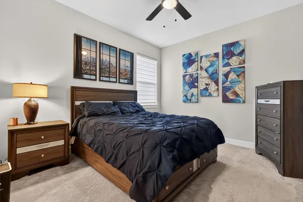 a bedroom with a bed and a refrigerator