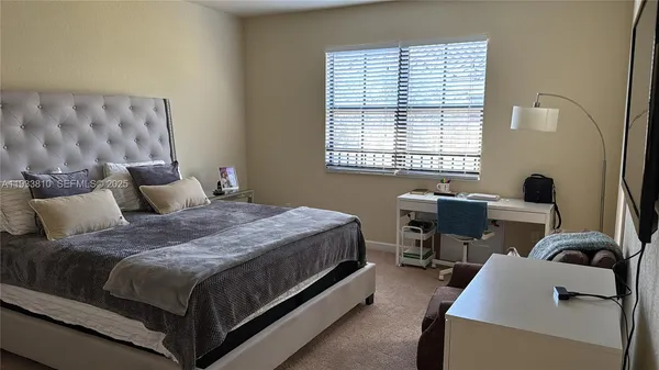 a bedroom with a bed and a computer on the desk