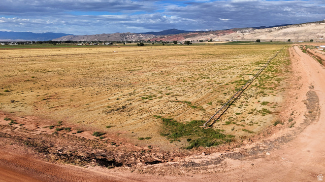 2070 East Tbd Road North Richfield, UT 84701 - Photo 5 of 35 Expansive open land with a dirt road access, distant mountain range, and scattered vegetation