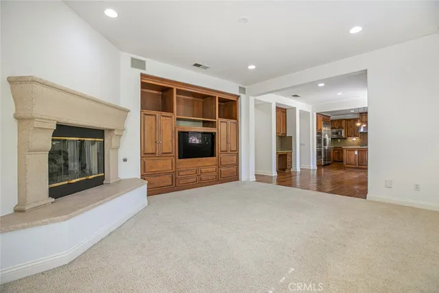 an empty room with wooden floor chandelier and windows