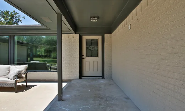 a view of a porch with furniture and garden