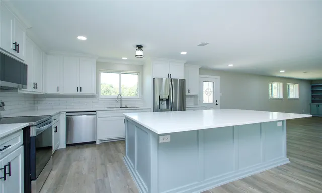 a kitchen with a stove a sink and a refrigerator