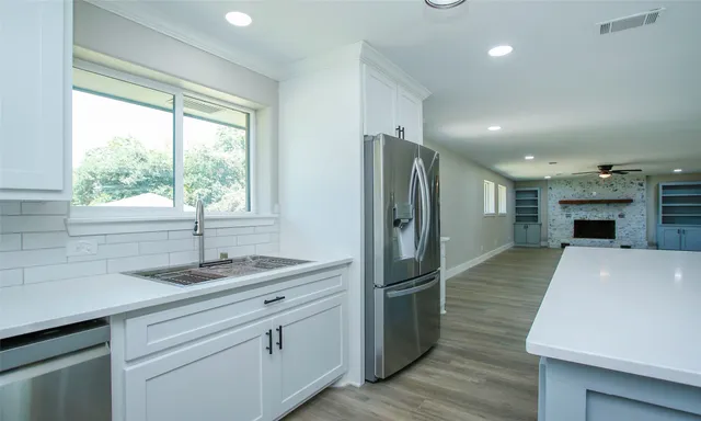 a kitchen with kitchen island granite countertop a sink appliances cabinets and a counter top space