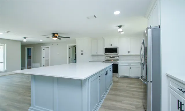 a kitchen with kitchen island a sink appliances and cabinets