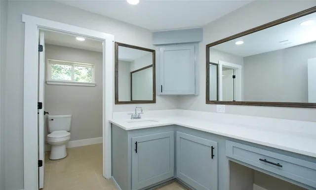 a bathroom with a toilet sink and mirror