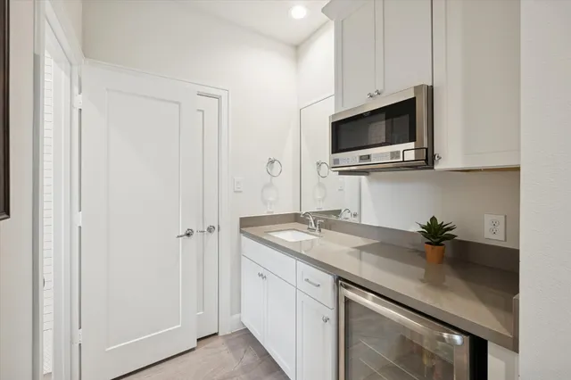a kitchen with a sink stainless steel appliances a microwave and cabinets