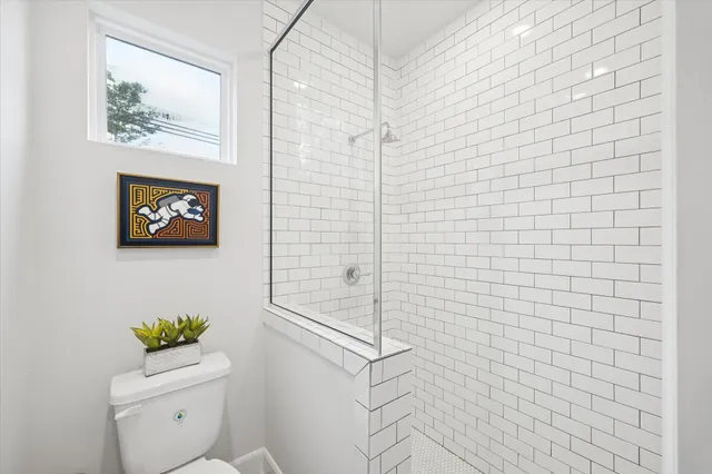 a bathroom with a toilet and a shower