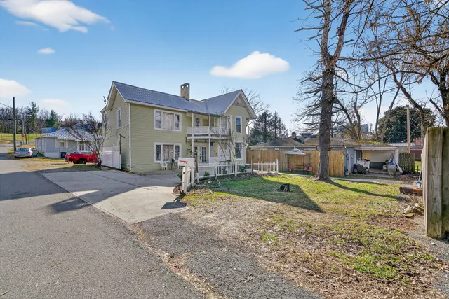 a view of a house with backyard and a tree