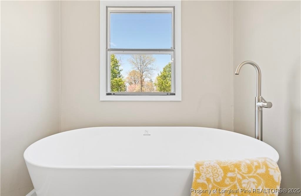 292 Grenada Road Fayetteville, NC 28306 - Photo 12 of 37 a white tub sitting in a bathroom next to a window