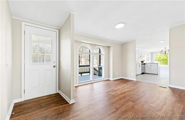 a view of a big room with wooden floor and windows
