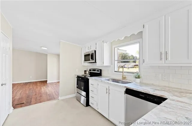 a kitchen with granite countertop a sink stove and cabinets