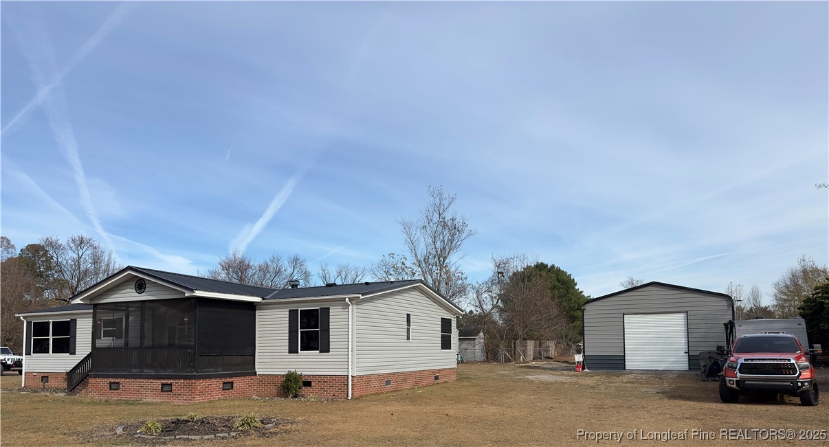 292 Grenada Road Fayetteville, NC 28306 - Photo 32 of 37 a view of a white house with a large space and a car parked in front of it