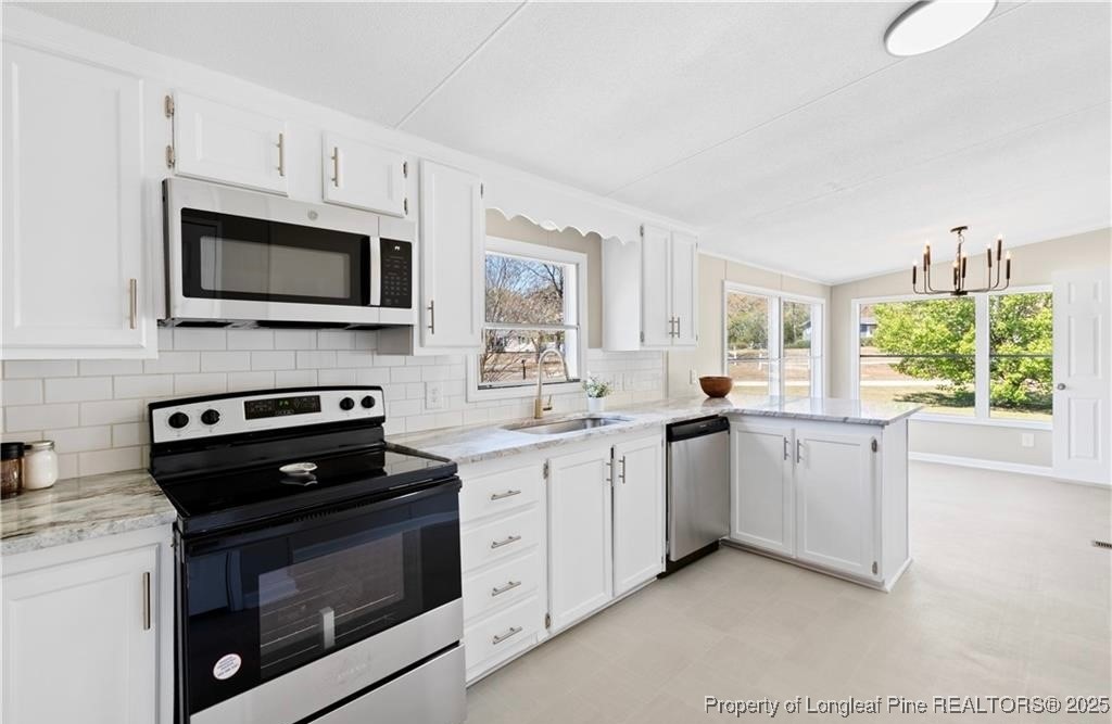 292 Grenada Road Fayetteville, NC 28306 - Photo 4 of 37 a kitchen with granite countertop cabinets stainless steel appliances and a window