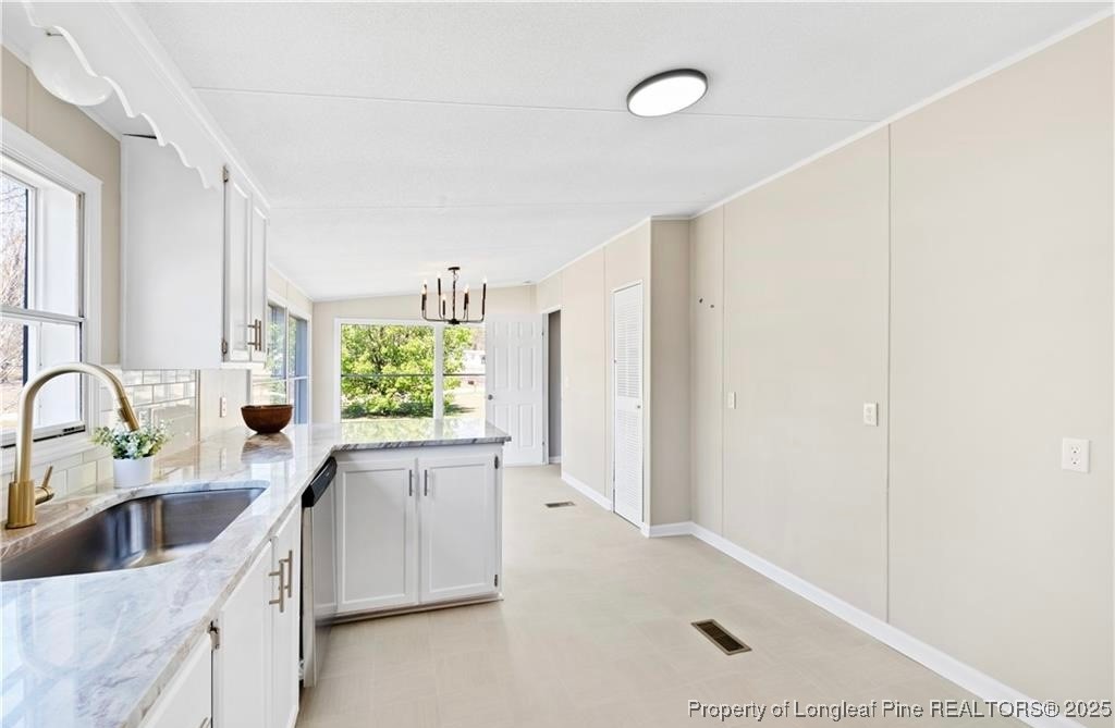 292 Grenada Road Fayetteville, NC 28306 - Photo 7 of 37 a kitchen with granite countertop a sink and a stove top oven