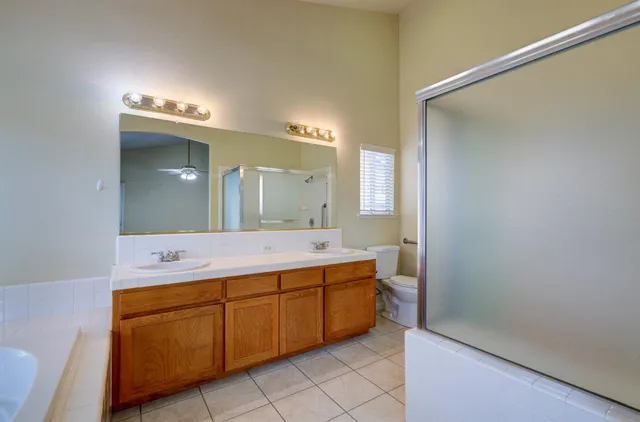 an empty room with windows and ceiling fan