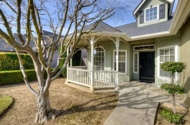 a view of a house with a large window and potted plants