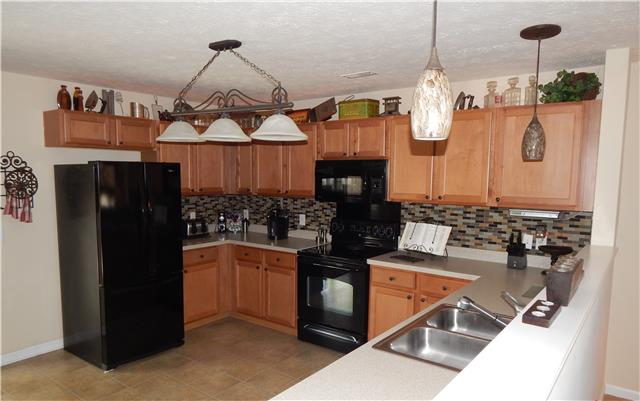 3960 Stephens Ridge Way Antioch, TN 37013 - Photo 8 of 20 Kitchen features toffee colored cabinets, over/under cabinet lighting, beautiful glass tile backsplash, custom hanging pendant lighting, all black appliances, convection microwave oven, stainless steel sink.