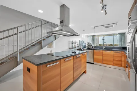 a kitchen with stainless steel appliances granite countertop a sink a stove and a refrigerator