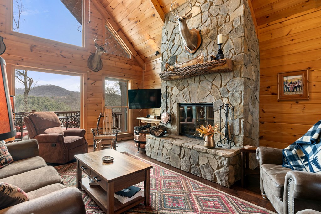 197 Cashes Valley Cherry Log, GA 30522 - Photo 13 of 67 a living room with furniture a fireplace and a floor to ceiling window