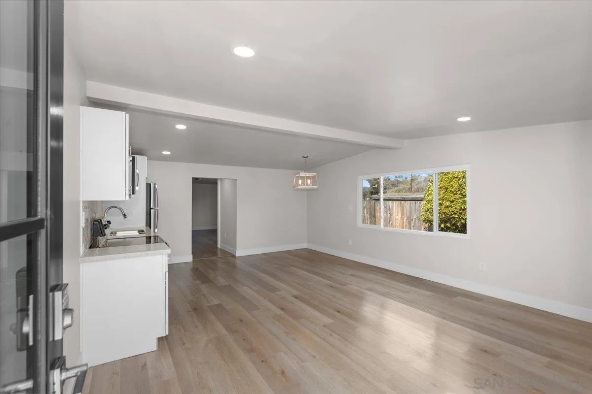 9255 Fairlawn Street Santee, CA 92071 - Photo 23 of 34 an empty room with wooden floor and a kitchen