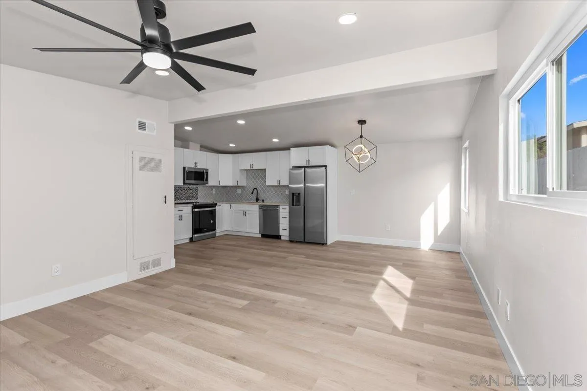 9255 Fairlawn Street Santee, CA 92071 - Photo 4 of 34 a view of a kitchen with a refrigerator a ceiling fan and wooden floor