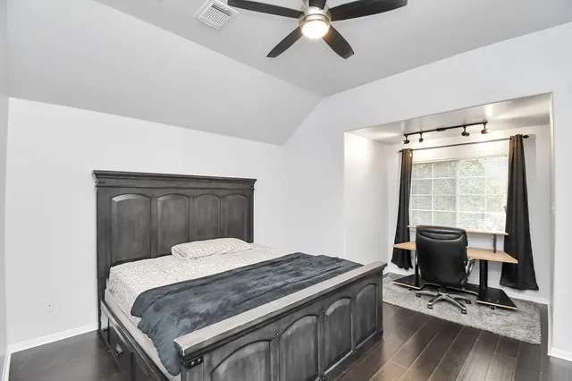 a bedroom with a bed and wooden floor