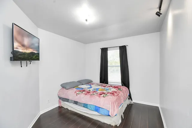 a bedroom with a bed and a painting on the wall