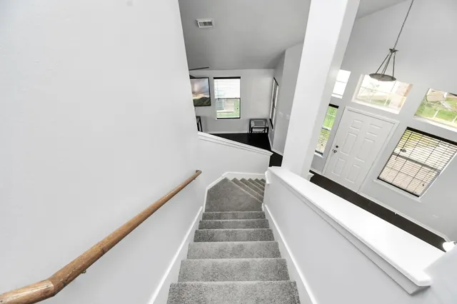 a view of a hallway with wooden floor and staircase