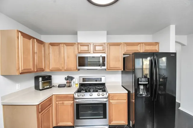 a kitchen with stainless steel appliances granite countertop a refrigerator stove and sink
