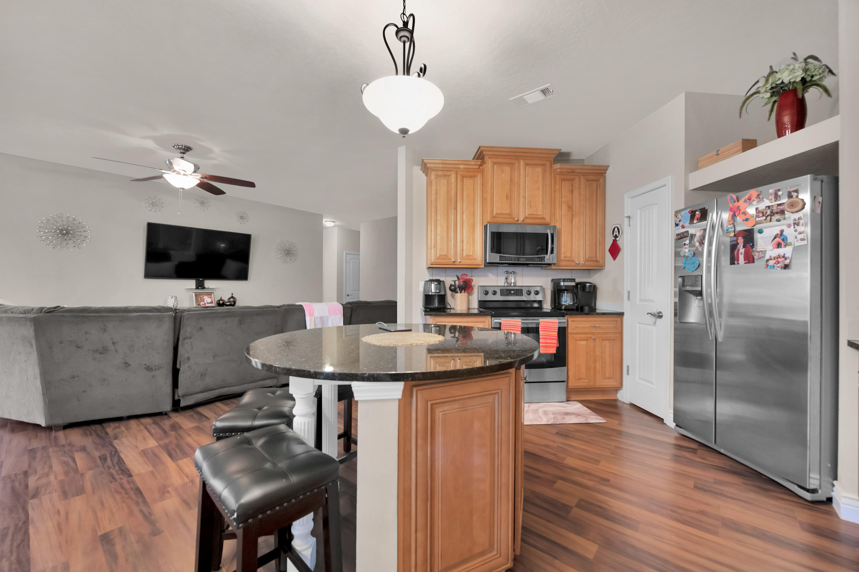 4608 Hermosa Road Crestview, FL 32539 - Photo 6 of 26 a kitchen with stainless steel appliances granite countertop a sink dishwasher a stove a refrigerator with a dining table and chairs with wooden floor