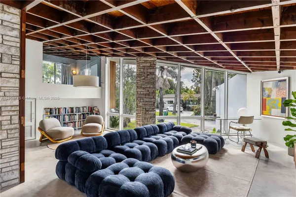 a living room with furniture a fireplace and a large window