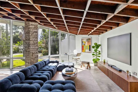 a living room with furniture a flat screen tv and a large window