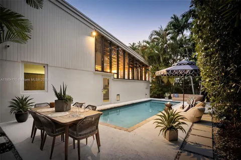 a front view of a house with a yard and potted plants
