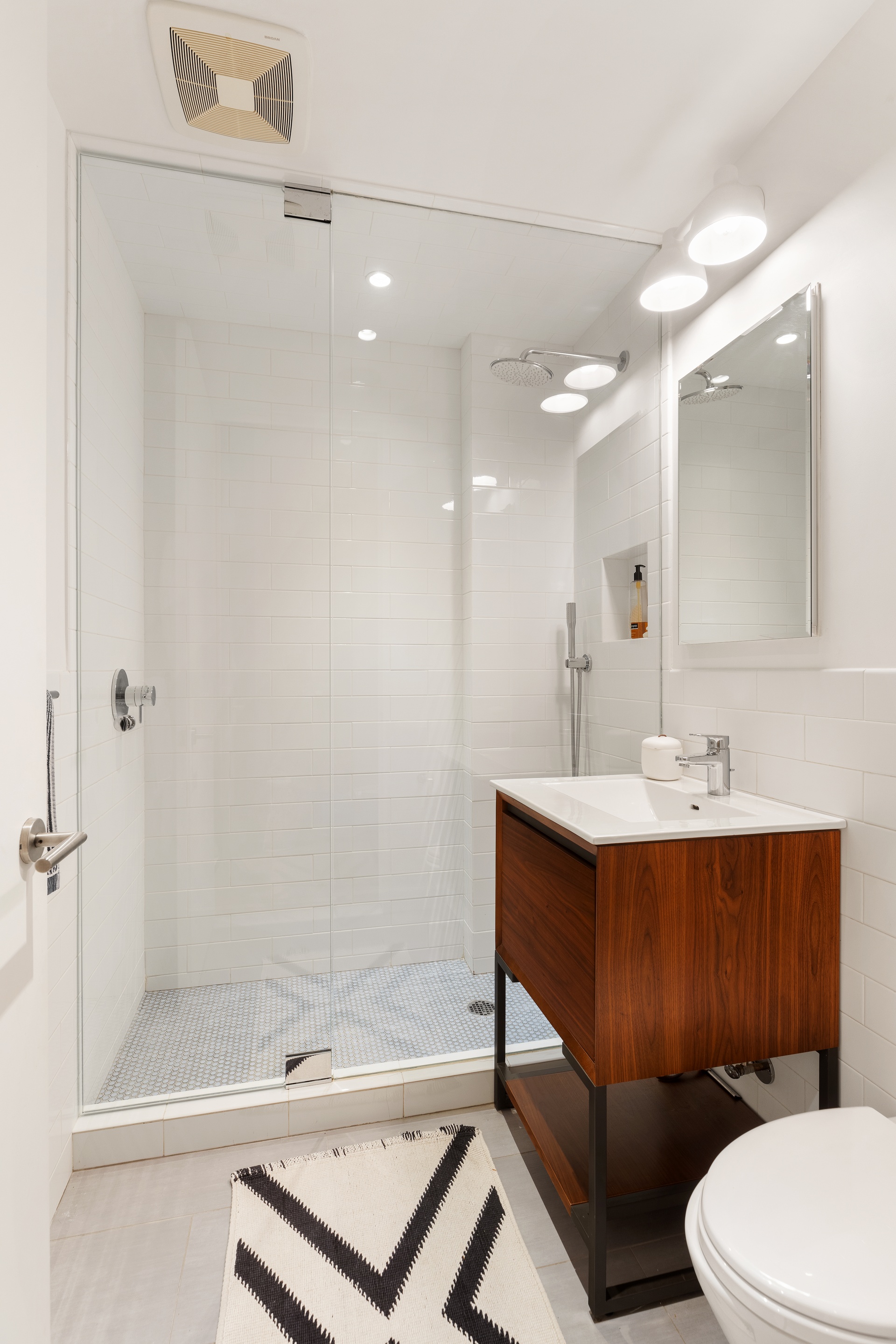 121 Mercer Street, Unit 4 Manhattan, NY 10012 - Photo 12 of 14 a bathroom with a sink mirror vanity and toilet