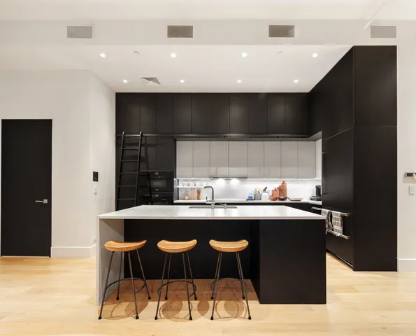 a kitchen with stainless steel appliances granite countertop a sink and a refrigerator