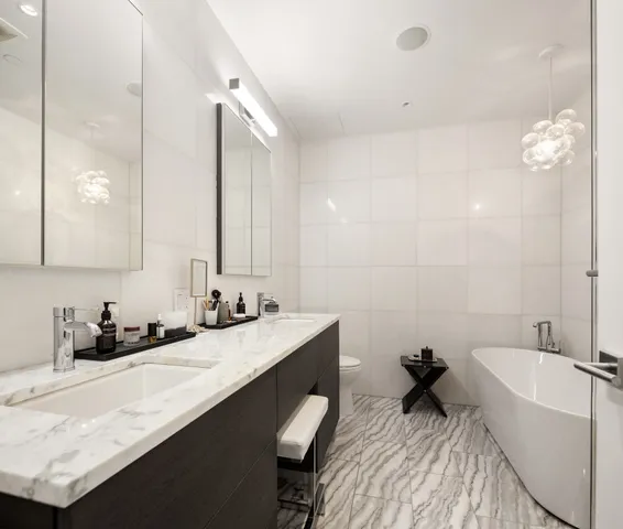 a bathroom with a double vanity sink a mirror and a bathtub