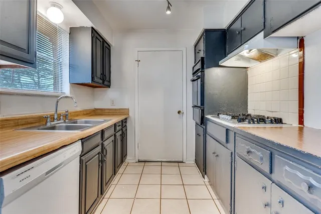 a kitchen with a sink stove top oven and cabinets