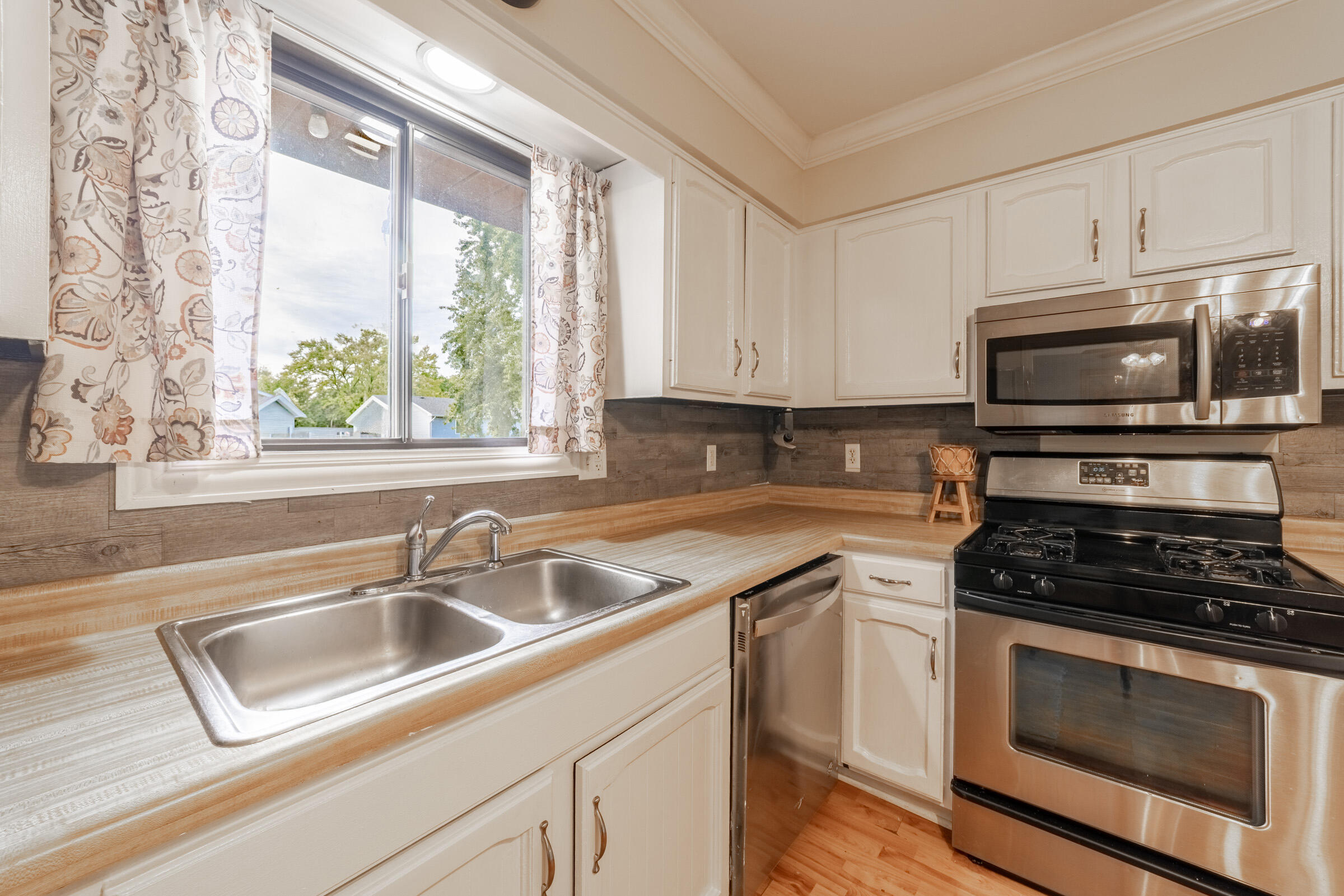 6331 Broughton Avenue Portage, IN 46368 - Photo 17 of 51 a kitchen with granite countertop a sink cabinets stainless steel appliances and a window