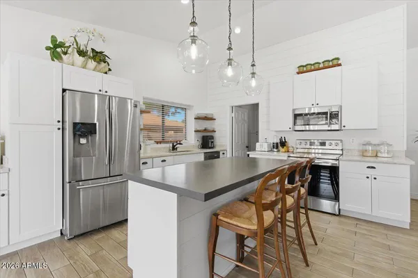 a living room with furniture kitchen view and a chandelier