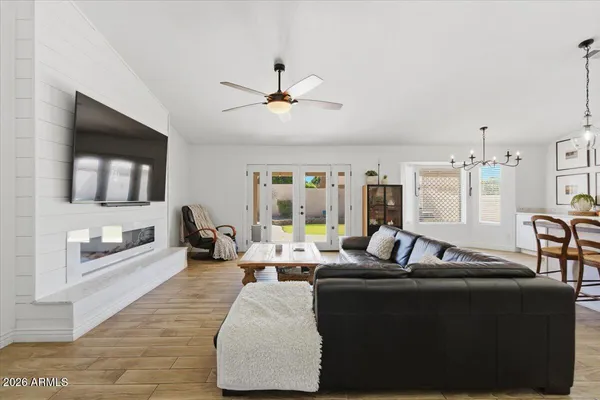 a large living room with stainless steel appliances granite countertop couches a flat screen tv and kitchen view