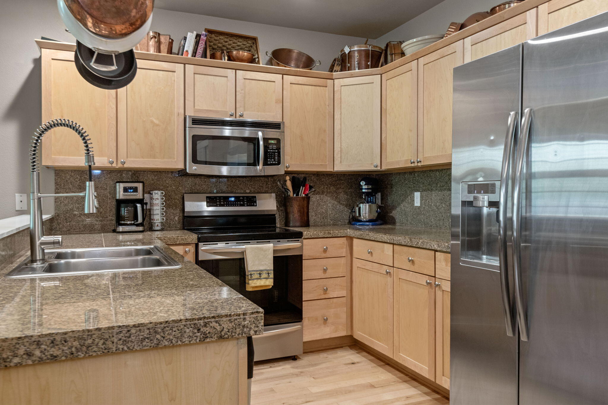 720 North Hindeman Street Sisters, OR 97759 - Photo 5 of 25 a kitchen with stainless steel appliances granite countertop a sink a stove and a refrigerator