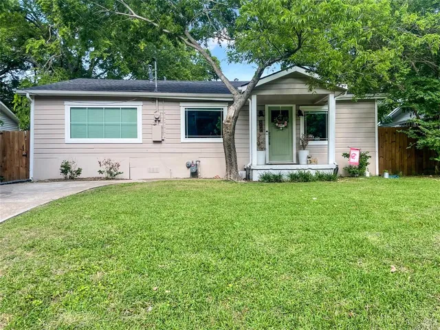 a front view of a house with a yard and trees