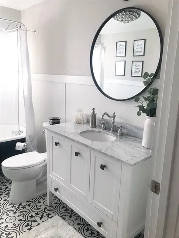 a bathroom with a toilet a sink and a mirror