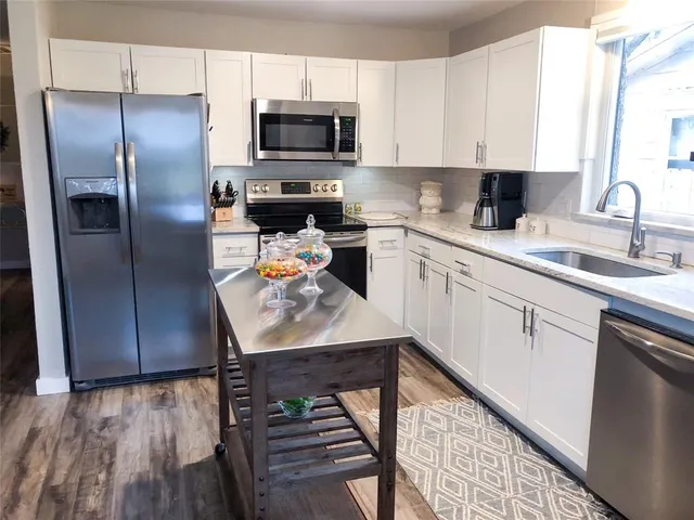 a kitchen with stainless steel appliances cabinets a sink and a stove