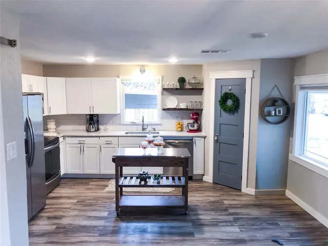 a kitchen with stainless steel appliances granite countertop a refrigerator and a stove top oven