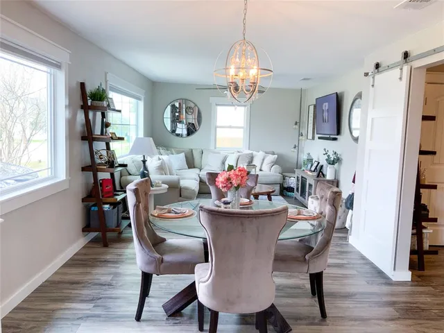 a dining room with furniture a chandelier and wooden floor