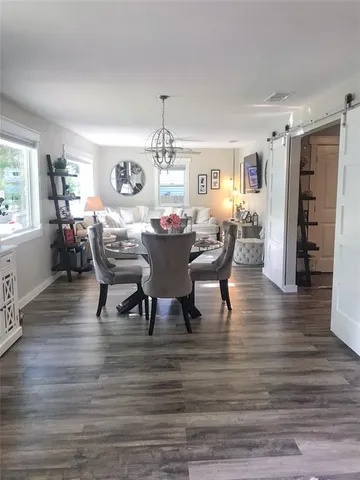 a dining room with furniture a chandelier and wooden floor