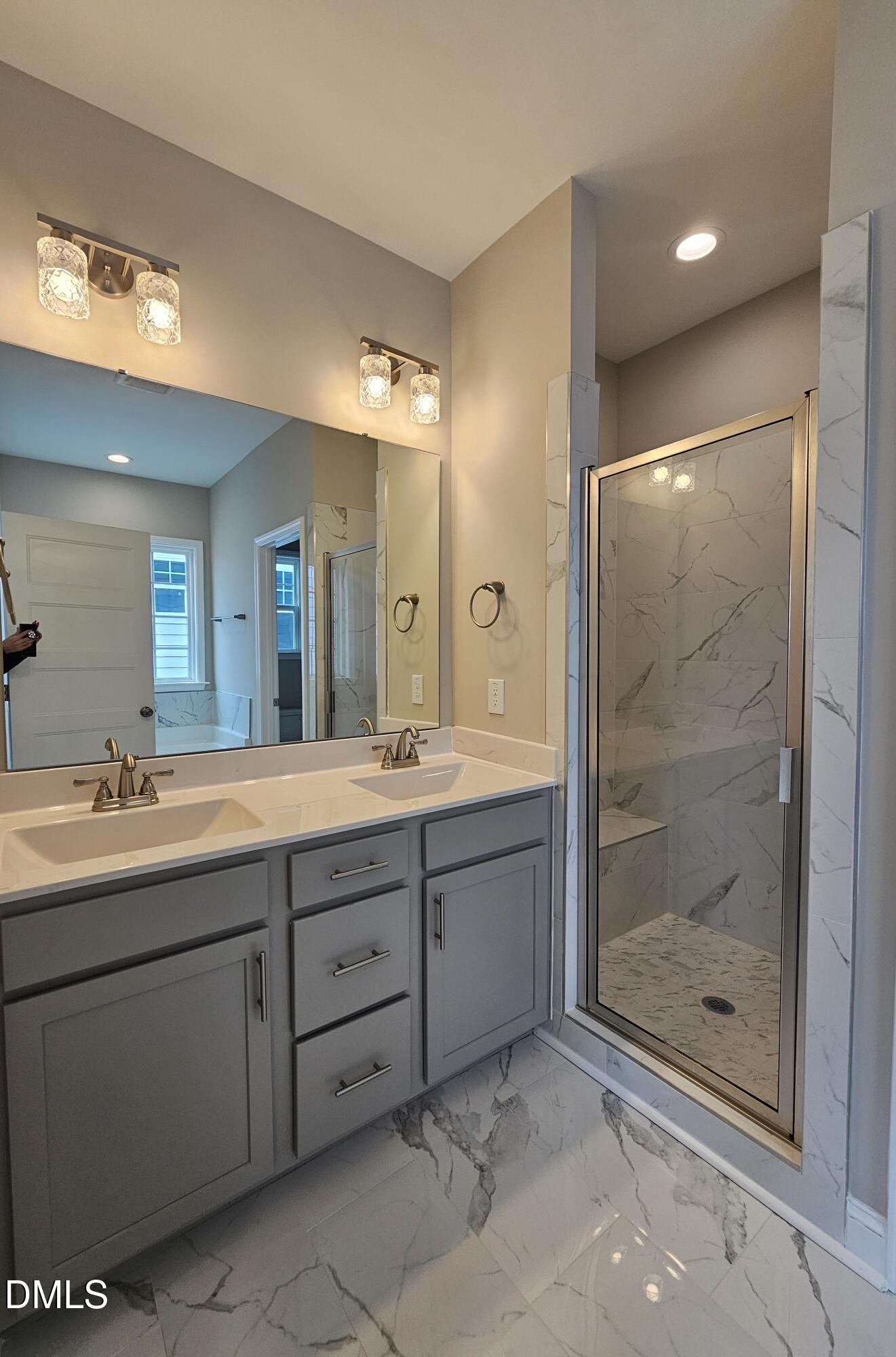 7994 Humie Olive Road Apex, NC 27502 - Photo 11 of 14 a bathroom with a shower sink and mirror